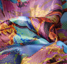 Atlasová látkla motiv listů/hadí kůže červená