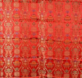 Látka brokát červeným se zlatým orientálním motivem 