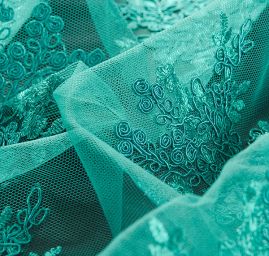 Krajka na hladkém tylu květy smaragdově zelená