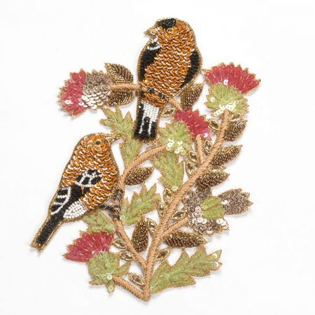 Aplikace ptáčci oranžovozlaté barvy na keři