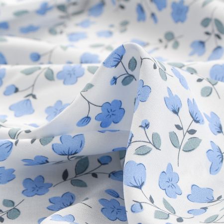 Viskozová šatová látka drobné květy pastel modrá